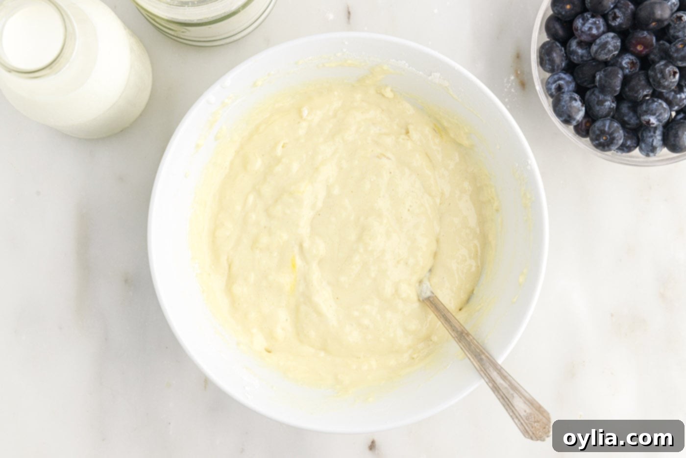 The perfectly lumpy, fluffy pancake batter in a bowl, ready for the blueberries.
