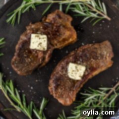 Two Sous Vide Steaks on a platter topped with butter and fresh rosemary.