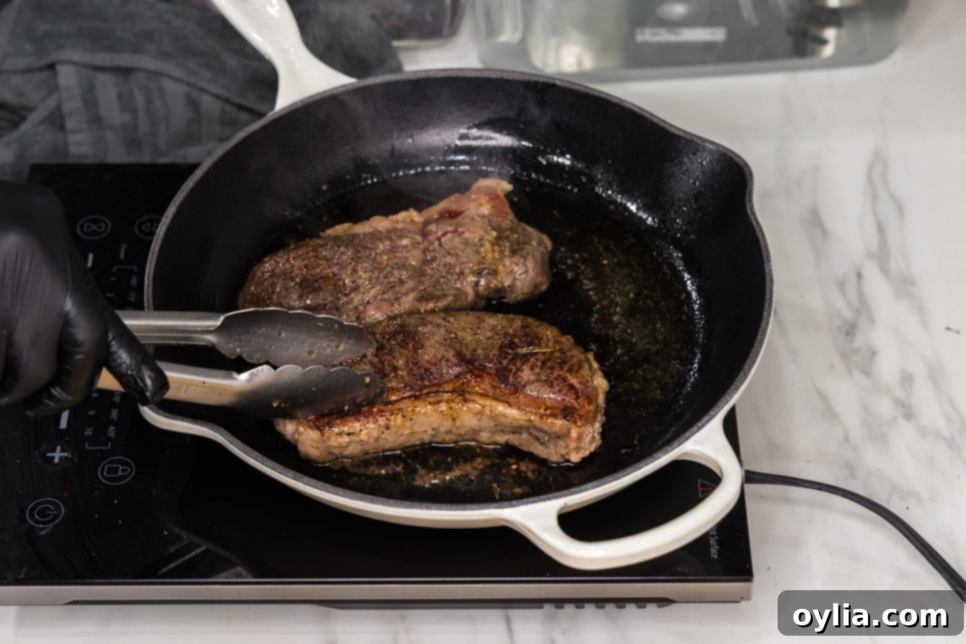 Two perfectly seared sous vide New York strip steaks resting on a cutting board, ready to be sliced.
