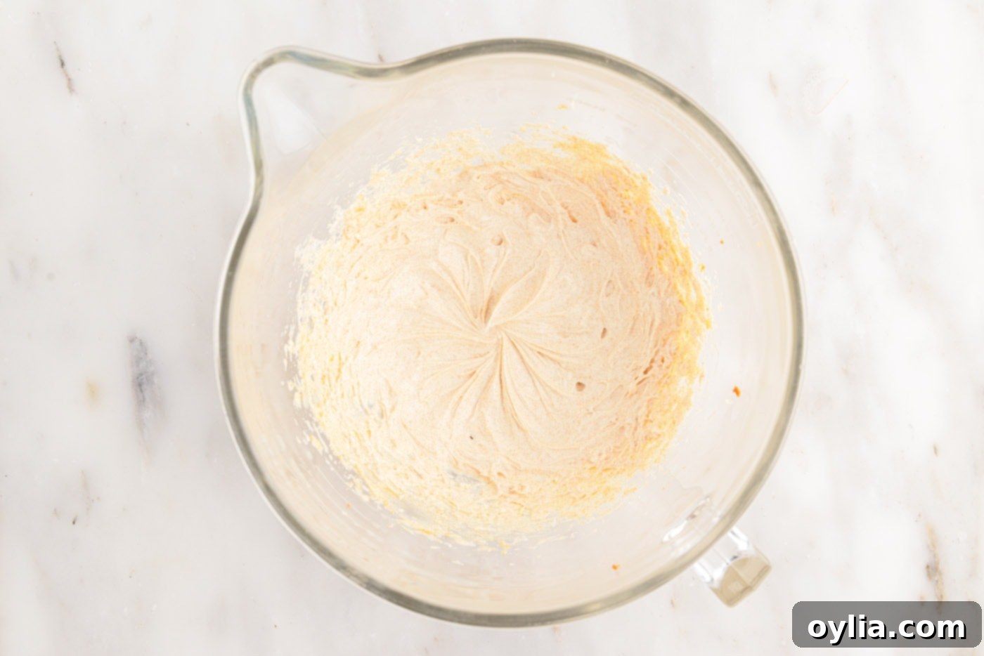 Whipping softened brown butter in a stand mixer until it becomes light and creamy.