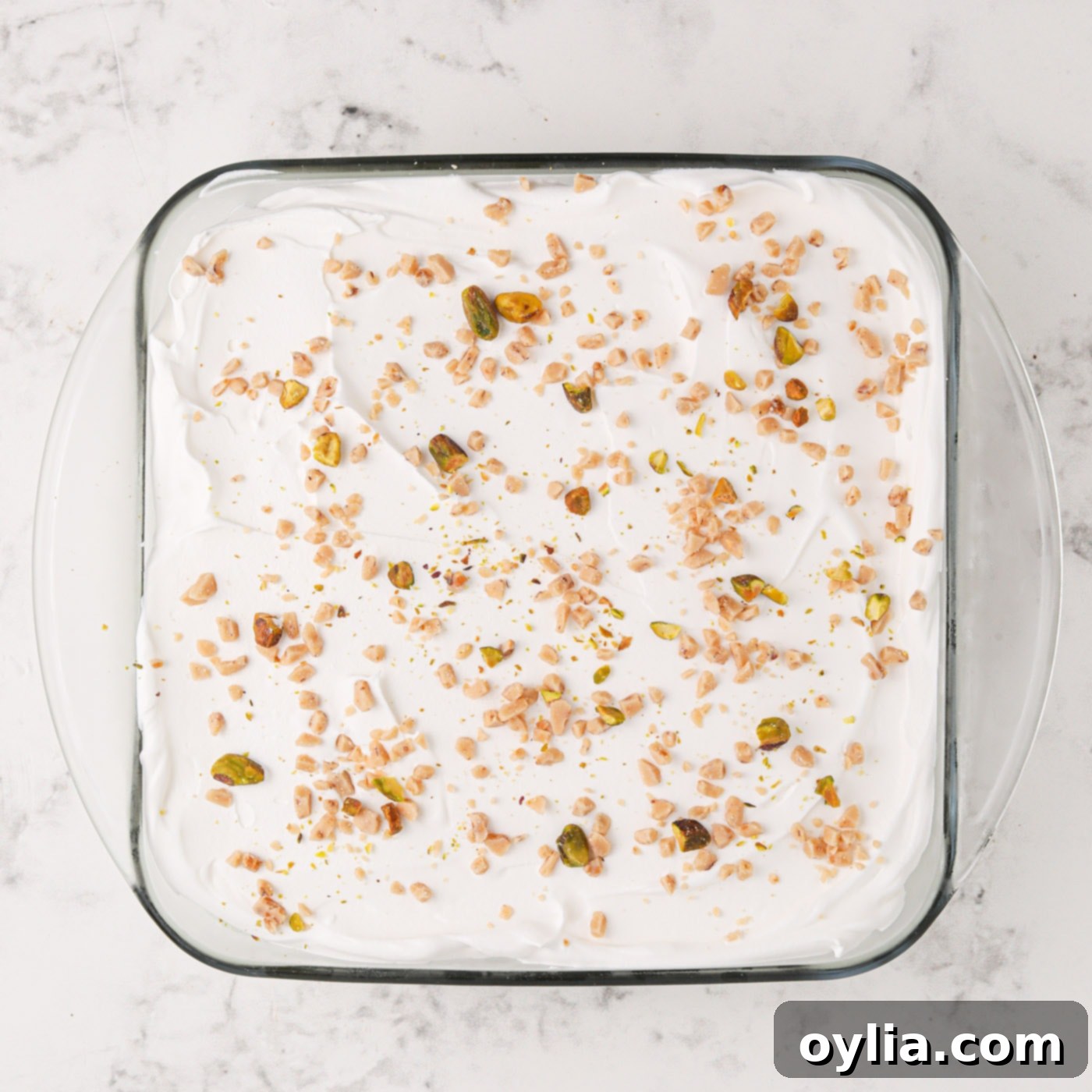 The finished Pistachio Ice Cream Cake, garnished with crushed pistachios, ready to be sliced and served.