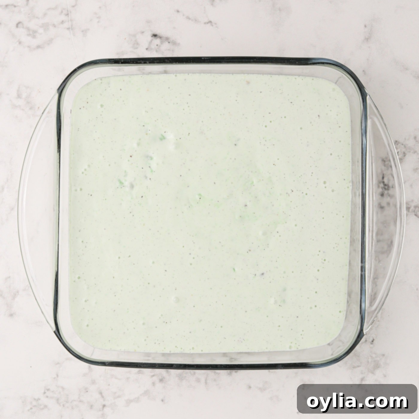 The pistachio ice cream mixture spread evenly over the crust in the baking dish.