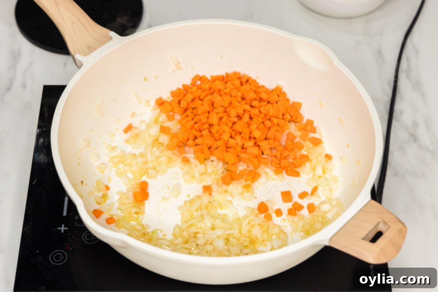 diced carrots added to skillet with onion, garlic, and ginger