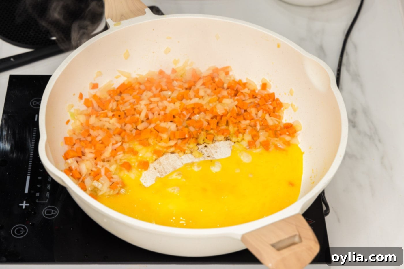 adding whisked eggs to stir fry veggies in skillet