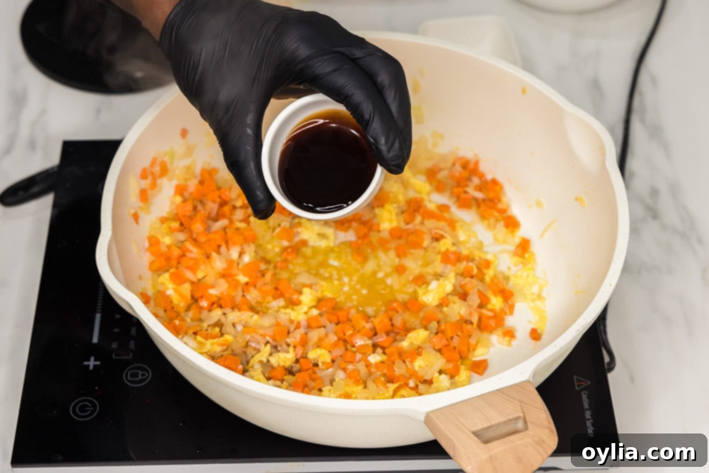 adding oyster sauce to skillet with egg and veggies