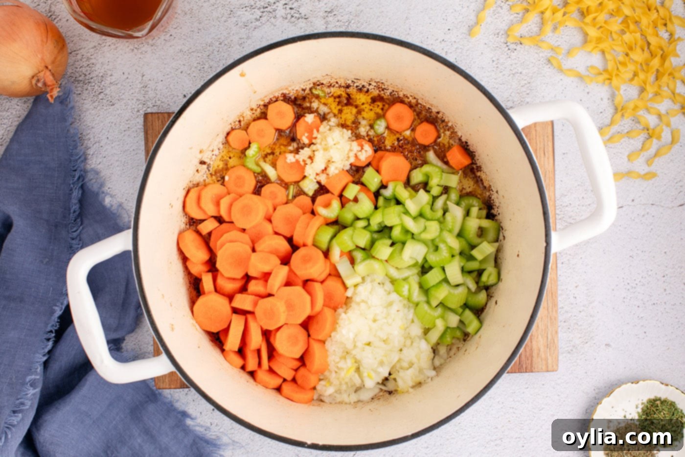 Hearty Beef Noodle Bliss 6 Adding chopped carrots, celery, onion, and minced garlic to the pot to sauté