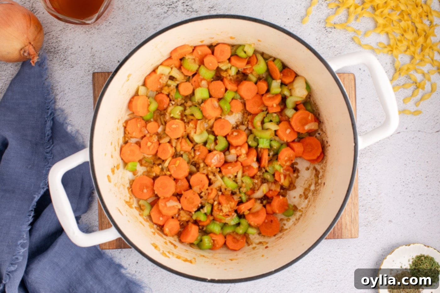 Cooked carrots, onion, celery, and garlic softened in a Dutch oven, ready for broth
