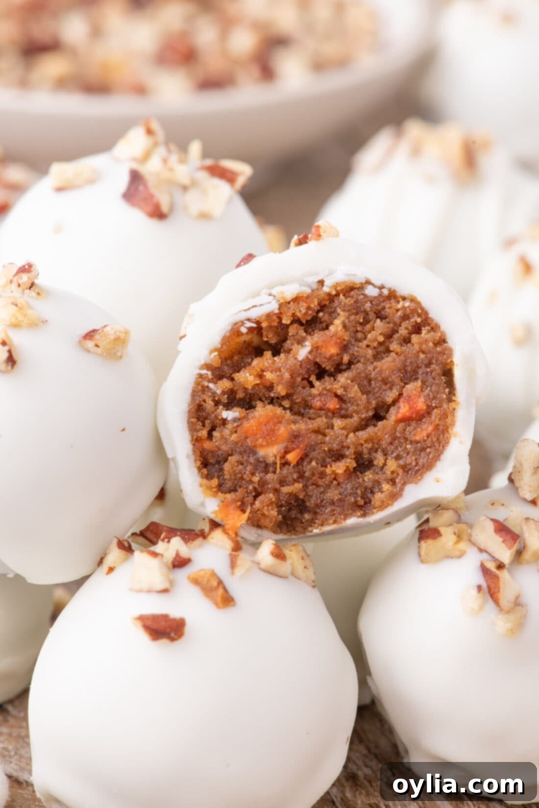 Close up photo of a Carrot Cake Truffle cut in half resting on more Carrot Cake Truffles