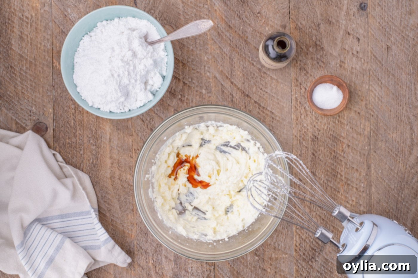 mixing vanilla with butter and cream cheese mixture