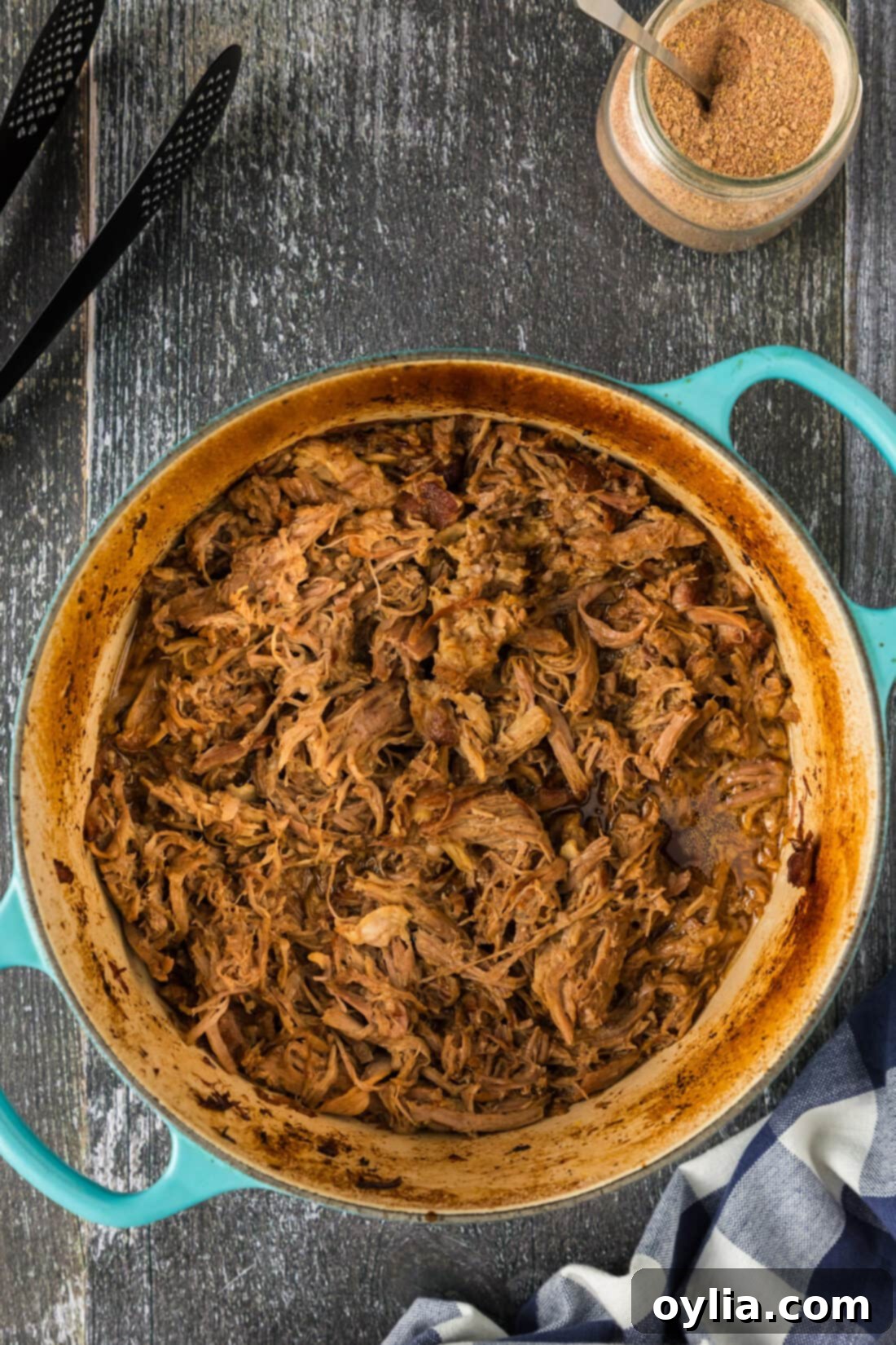 Pulled Pork Perfection 11 A close-up shot of a Dutch oven filled with rich, dark, and perfectly shredded pulled pork, glistening with its own juices.