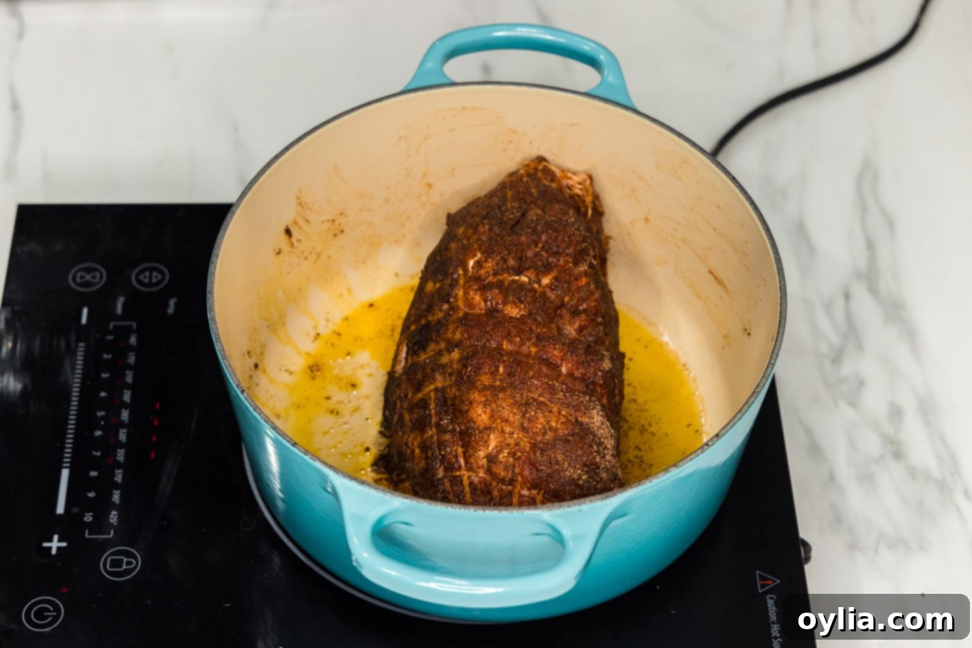 A pork shoulder searing in a hot Dutch oven, developing a rich brown crust.