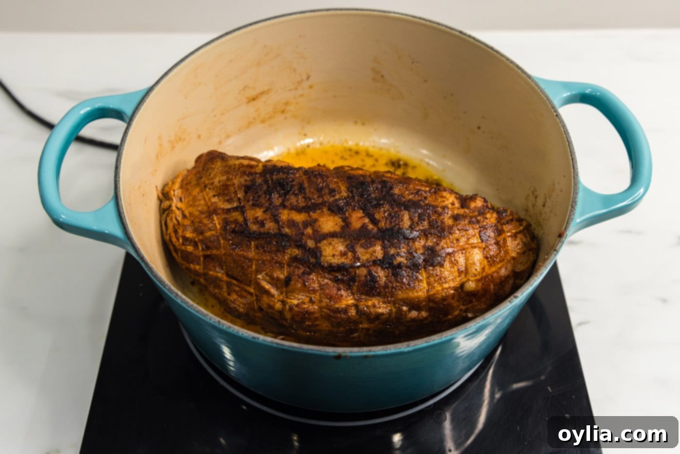 The seared pork shoulder, beautifully browned on all sides, resting in the Dutch oven.