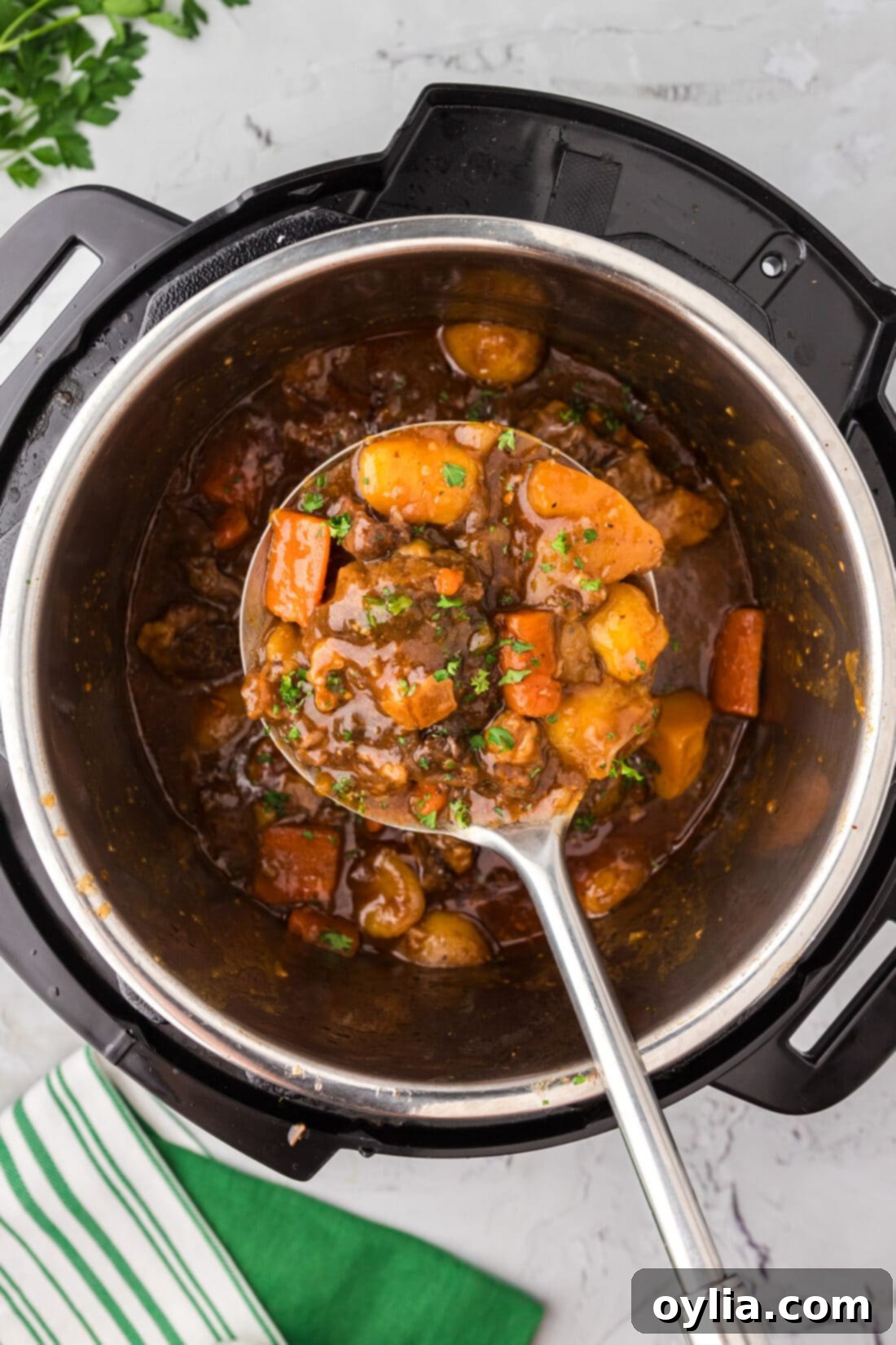 Serving spoon holding Instant Pot Oxtail over an Instant Pot