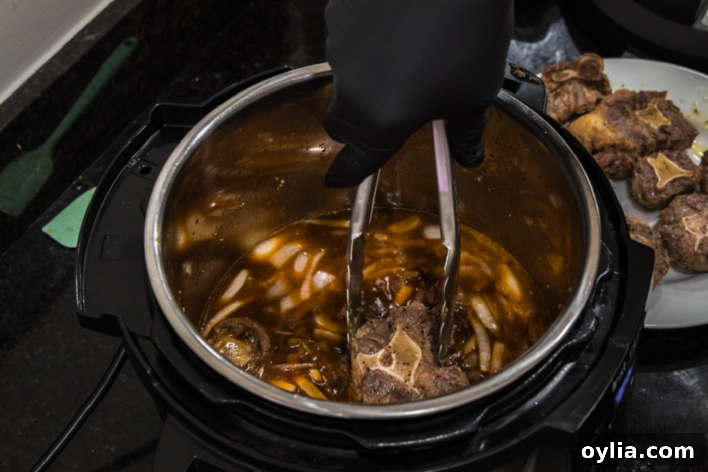 adding oxtail to sauce mixture in instant pot