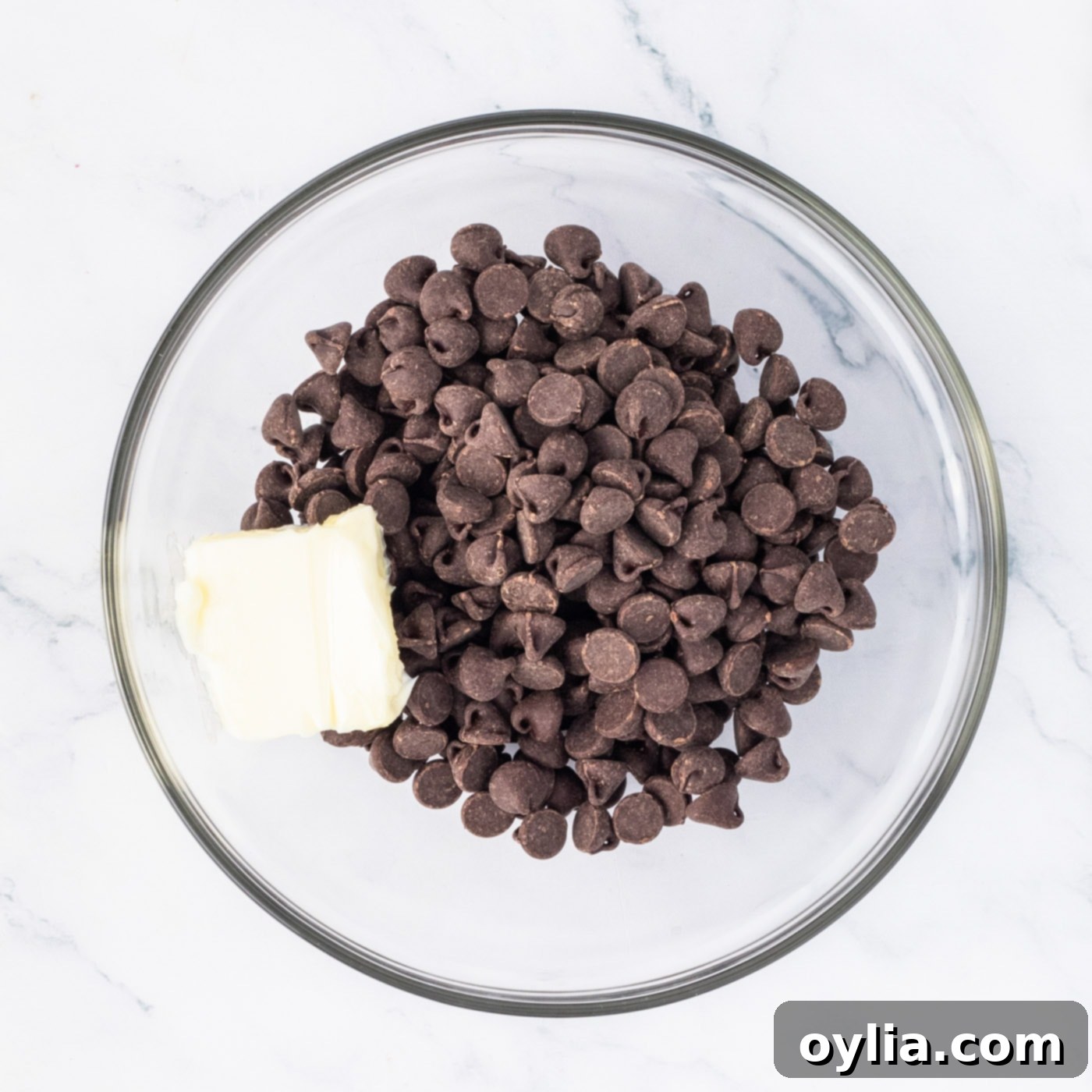 Remaining semi-sweet chocolate chips and butter in a bowl, ready to be melted for the fudge topping