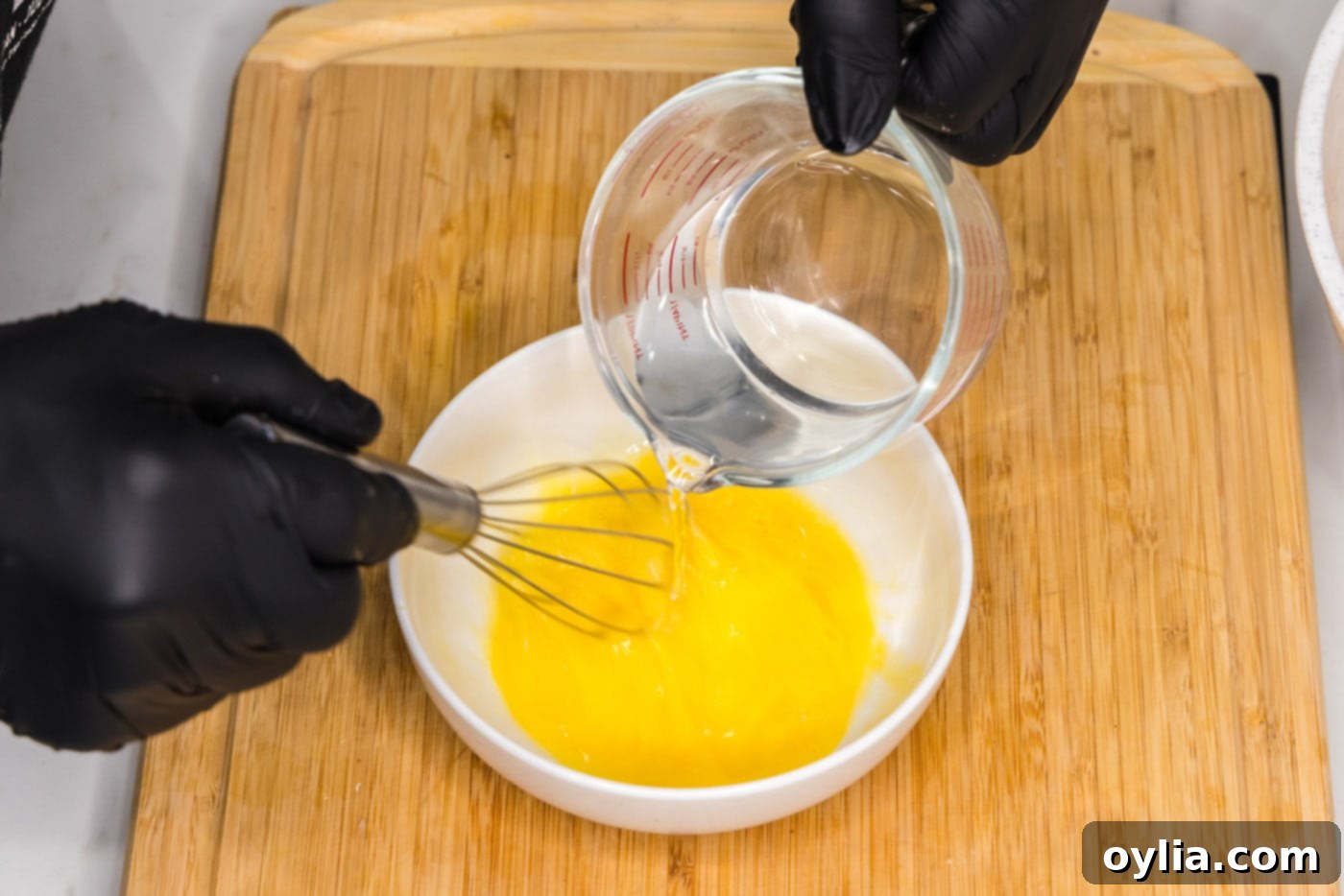 whisking egg with water in a bowl