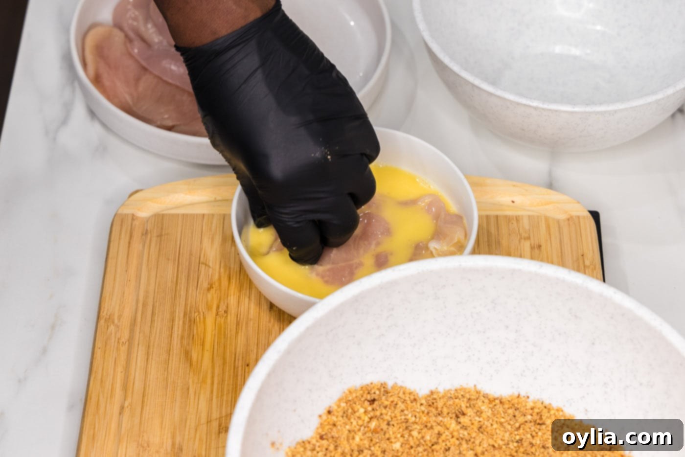 dipping chicken breast into egg