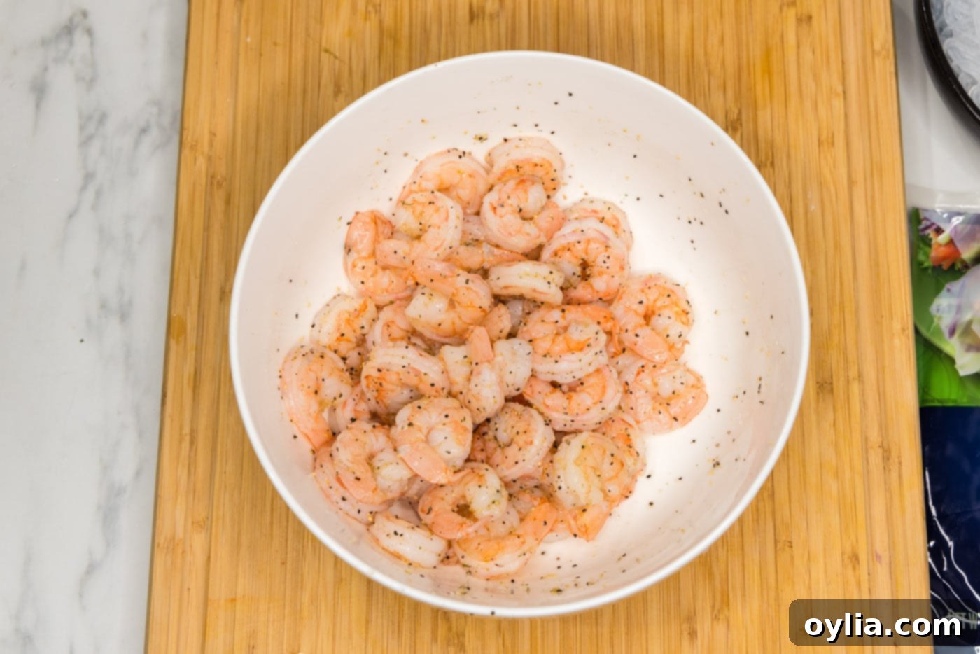 cooked shrimp in a bowl, seasoned with garlic salt and pepper, ready for spring rolls