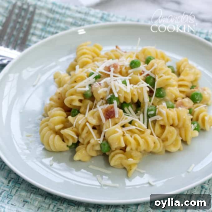 Rotini with peas and cheese on a plate with a fork