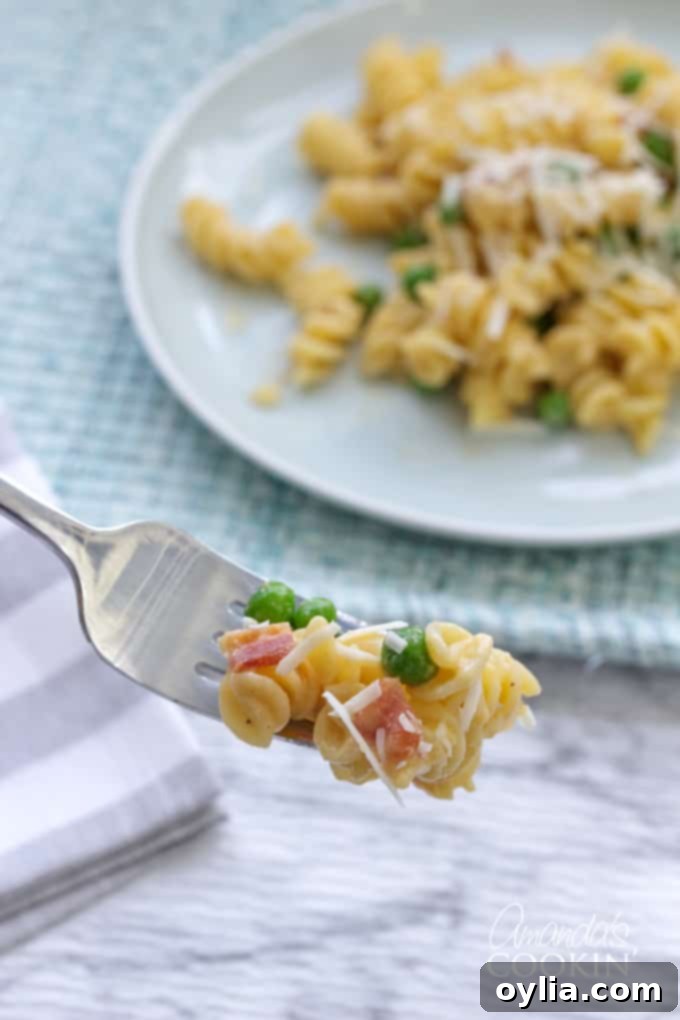 forkful of rotini peas and cheese, showing the creamy sauce