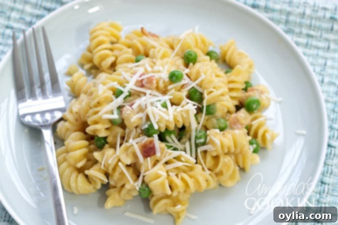 plate of rotini and cheese with peas and bacon