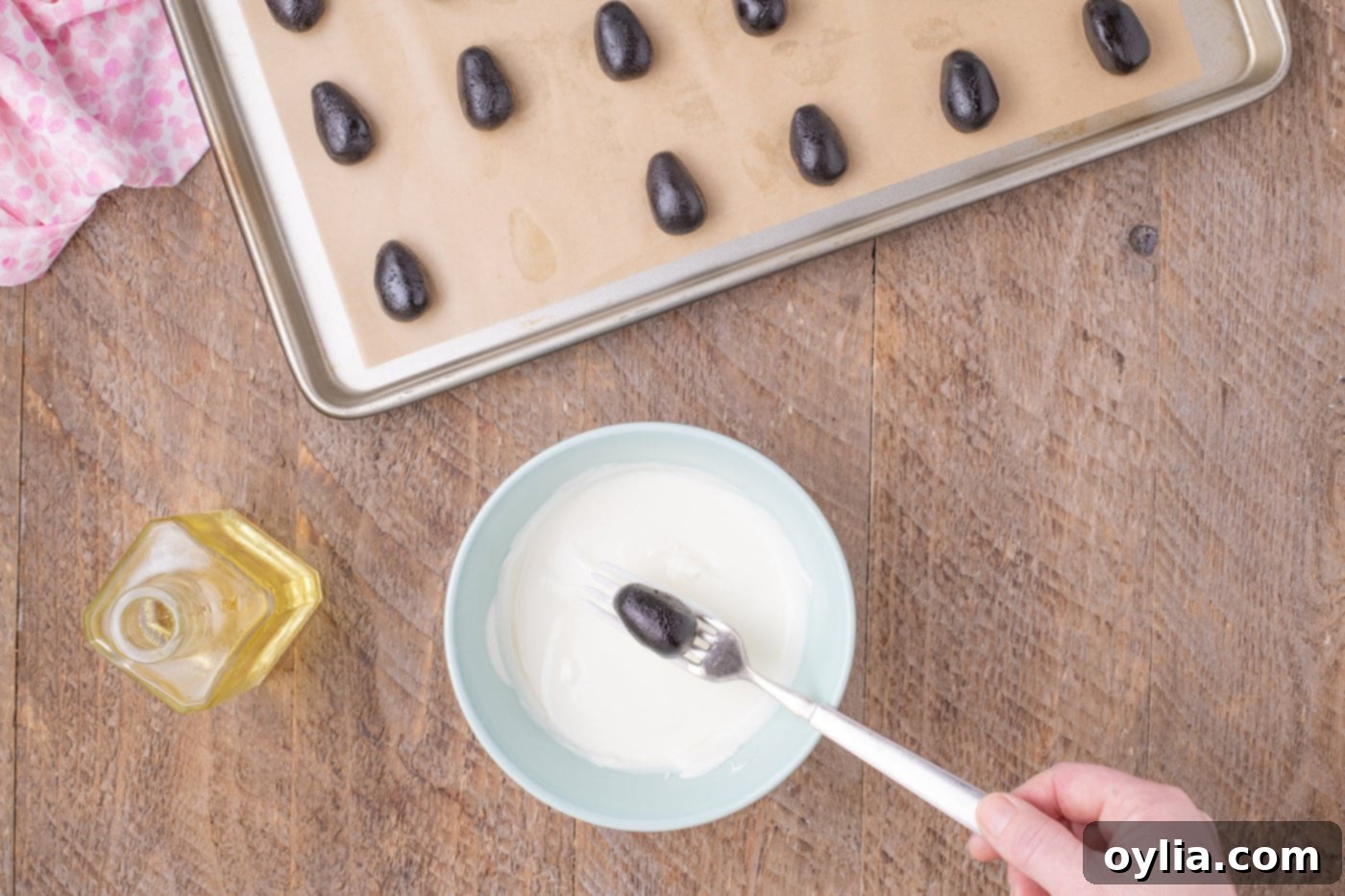 Dipping an Easter egg Oreo truffle into white chocolate coating