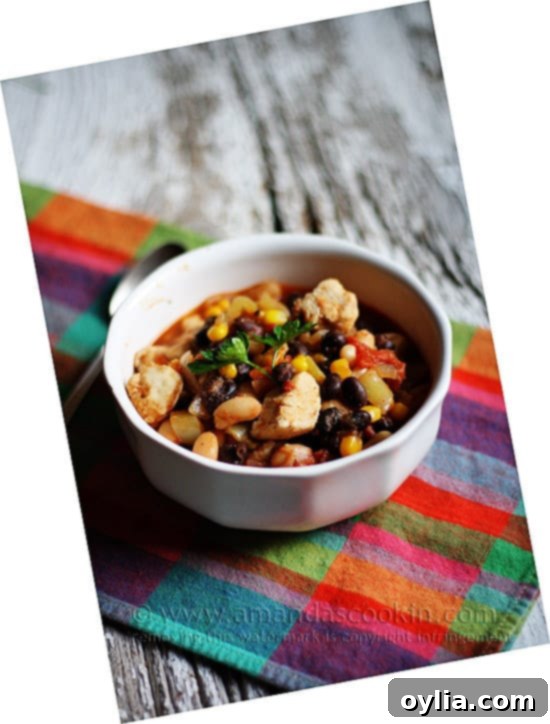 A bowl of chicken chili with black beans and corn, garnished with fresh cilantro.