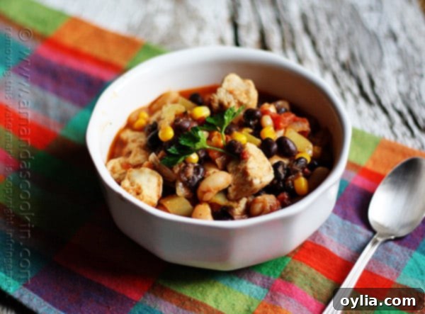 A beautifully presented bowl of chicken chili with black beans and corn, garnished and ready to be enjoyed.