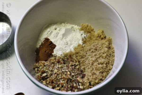 A mixing bowl of chopped pecans, packed brown sugar, unbleached all purpose flour and ground cinnamon.