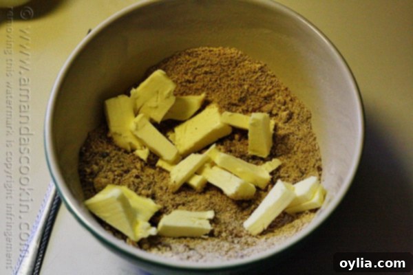A photo of butter squares added to the bowl of streusel topping.