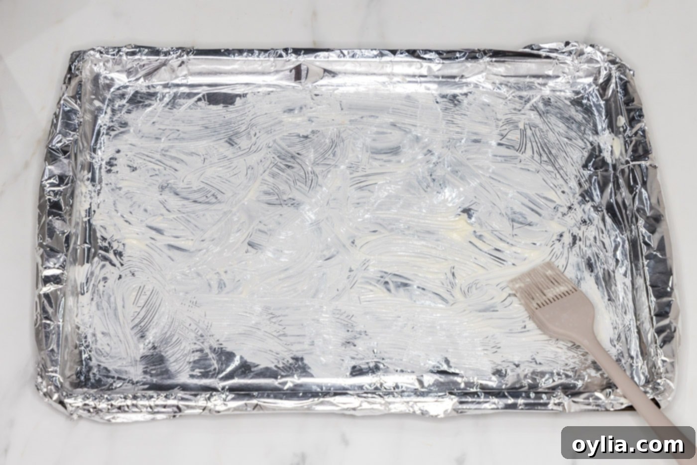 brushing aluminum foil with softened butter