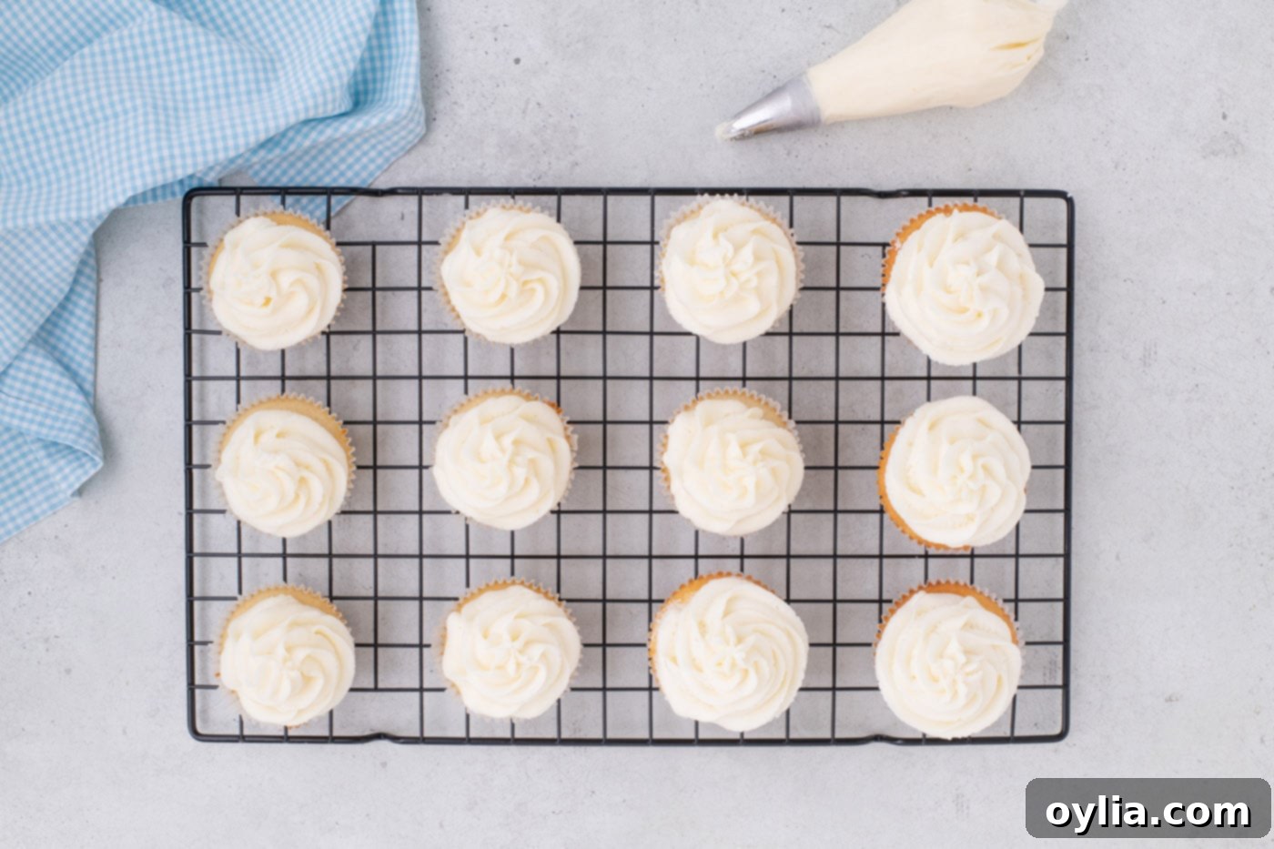 frosted vanilla cupcakes on a wire cooling rack
