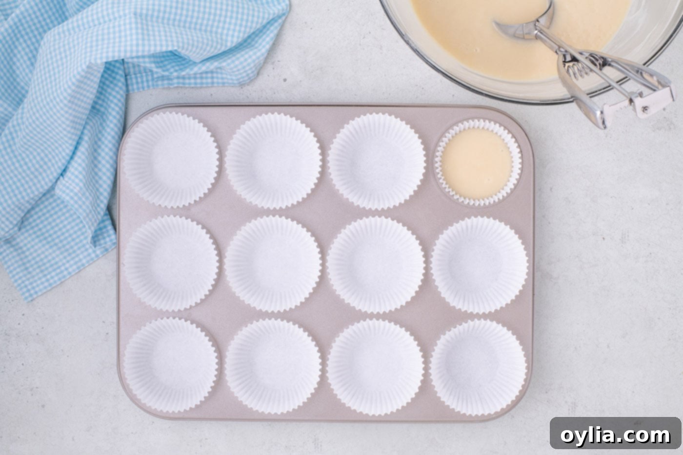 filling cupcake liners with vanilla cupcake batter