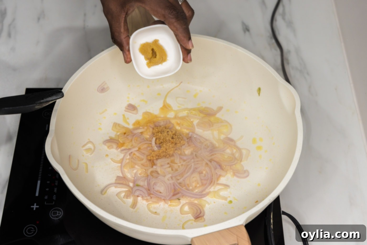 adding minced ginger to skillet of garlic and shallots