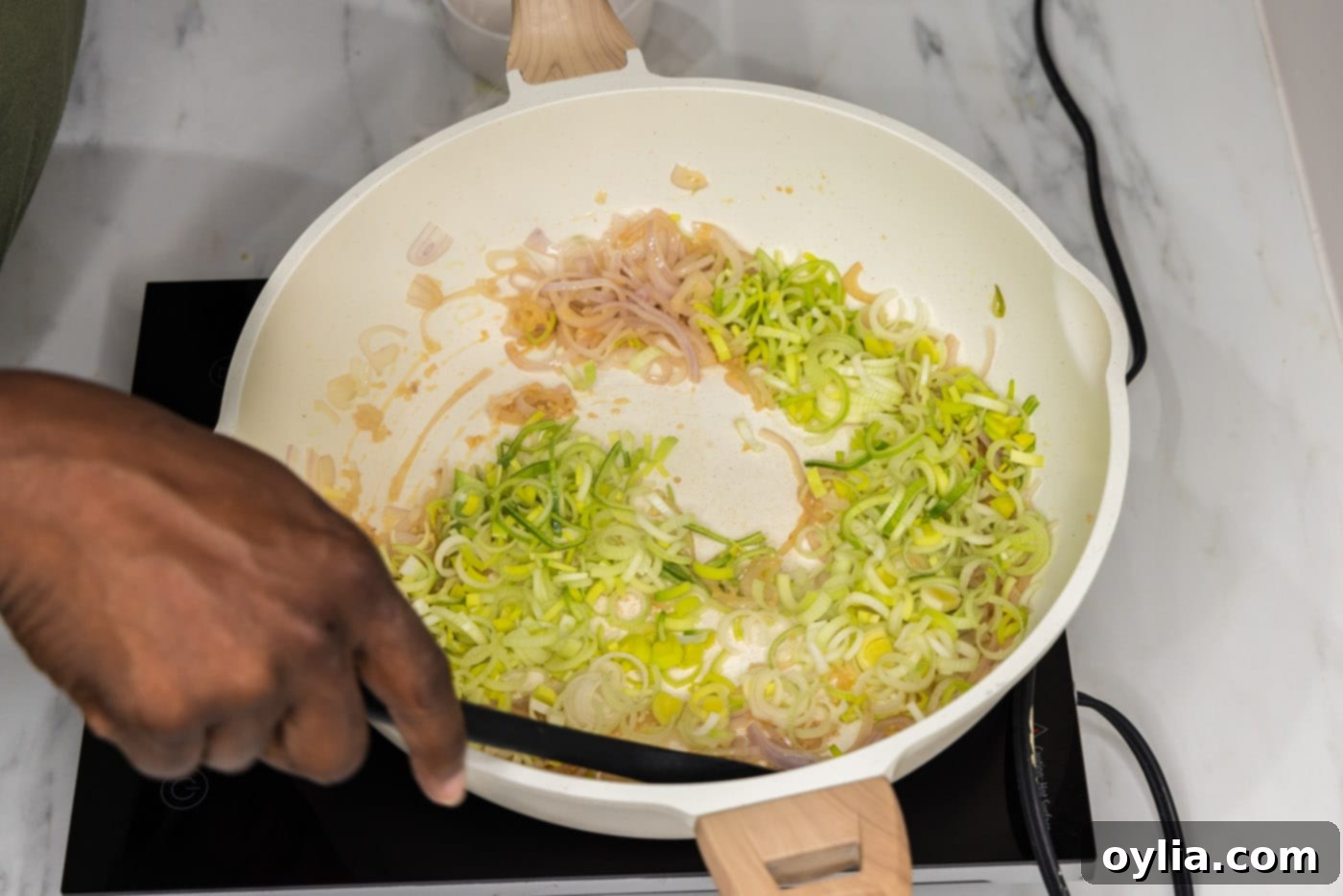 sauteeing leeks in a skillet with shallots and garlic
