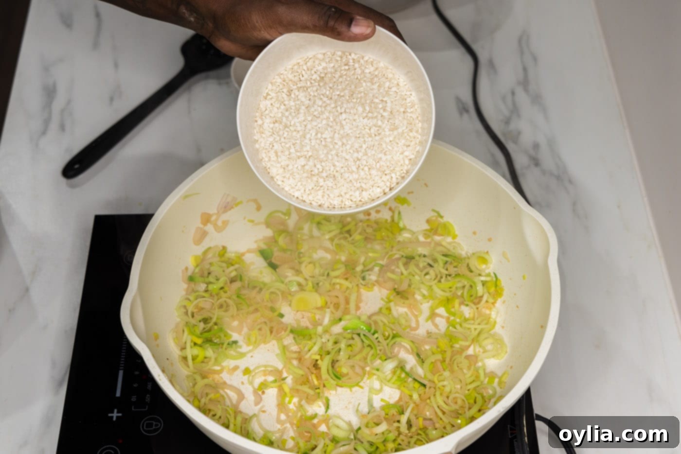 adding arborio rice to skillet with leeks and shallot mixture