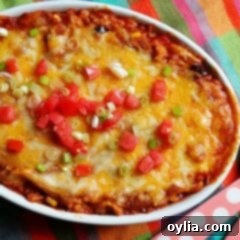 Chicken Tostada Bake 10 An overhead photo of a chicken tostada casserole with chopped green onions and tomatoes on top.