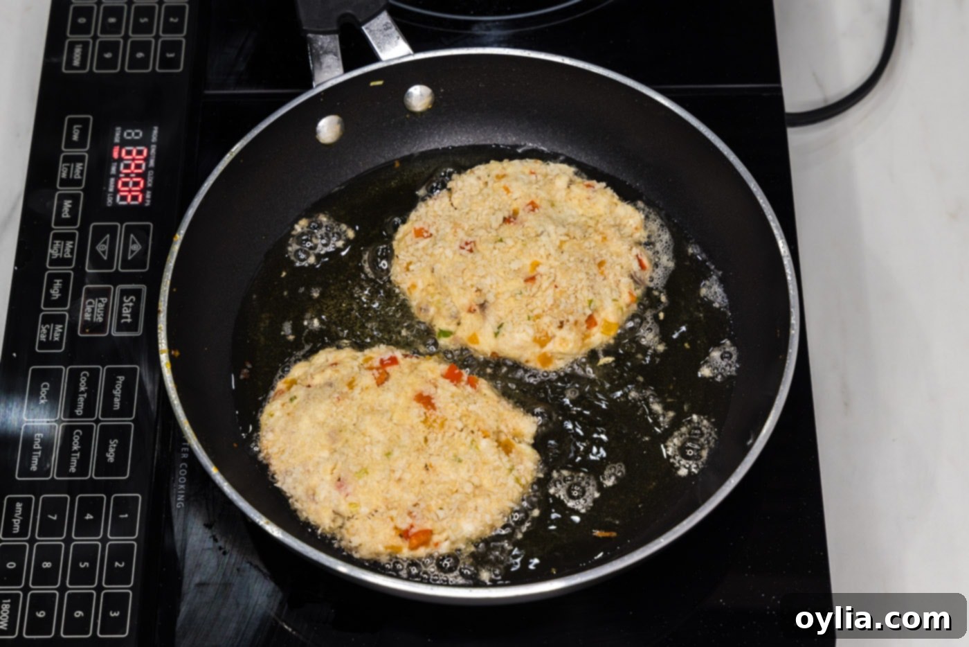 frying fish cakes in a skillet of hot oil