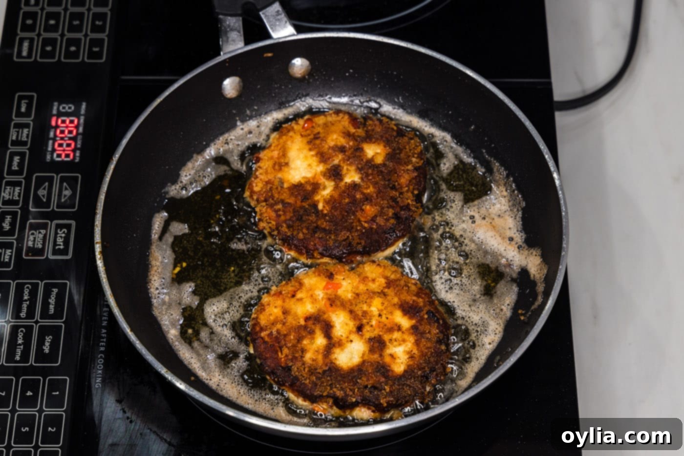 fried fish burgers resting in a skillet after cooking
