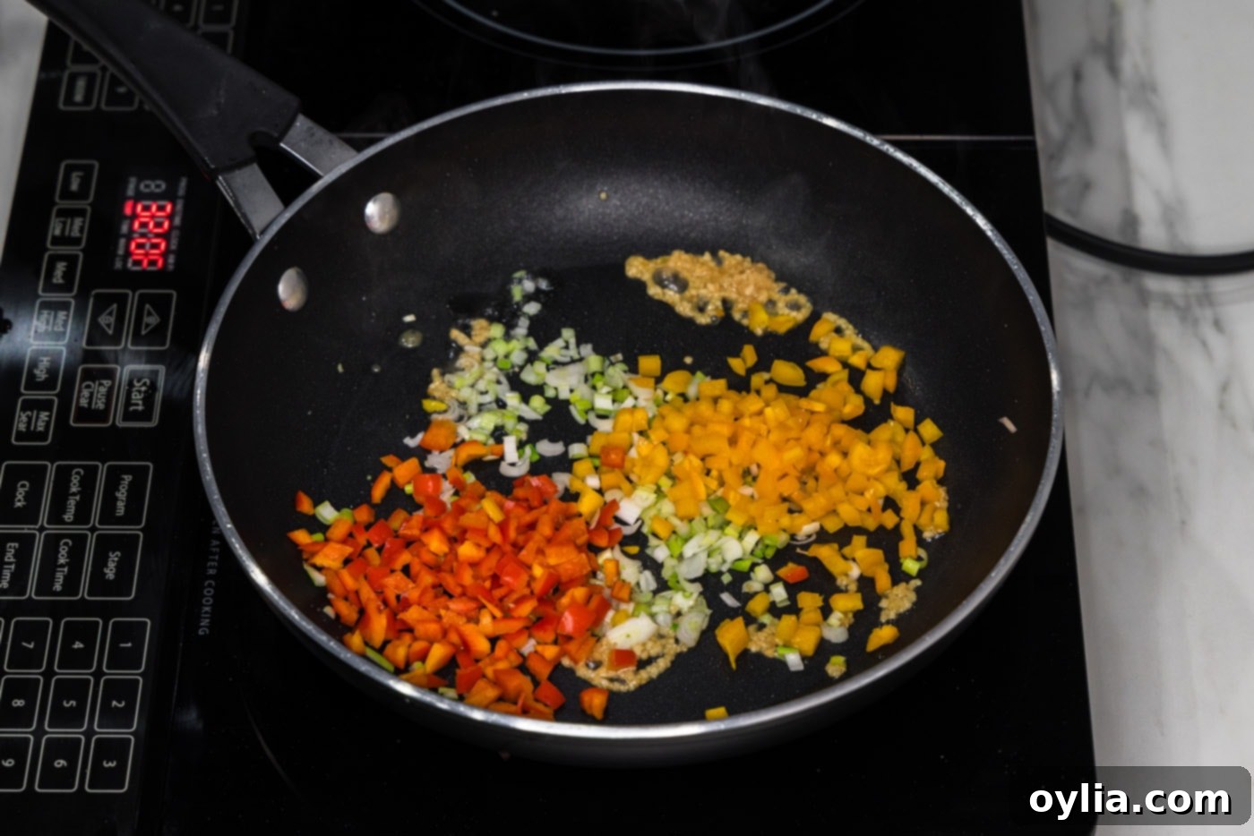 sweet peppers, minced garlic, and sliced green onions sizzling in a skillet