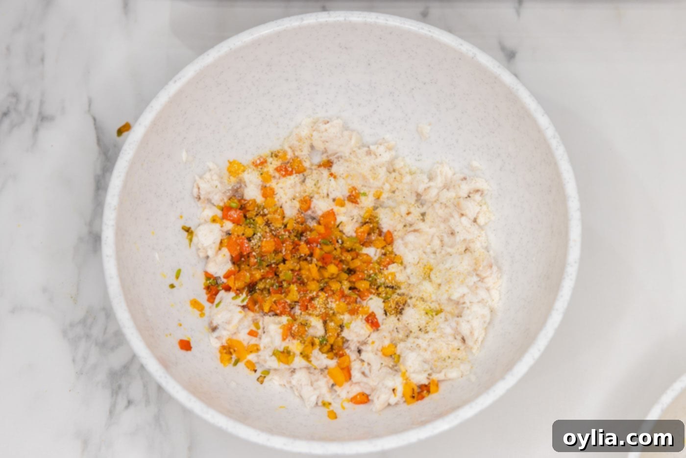 flaked fish with sauteed vegetables combined in a large mixing bowl