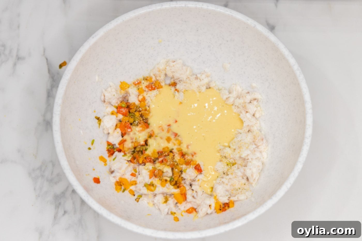 adding horseradish and other sauces to the fish mixture in a bowl