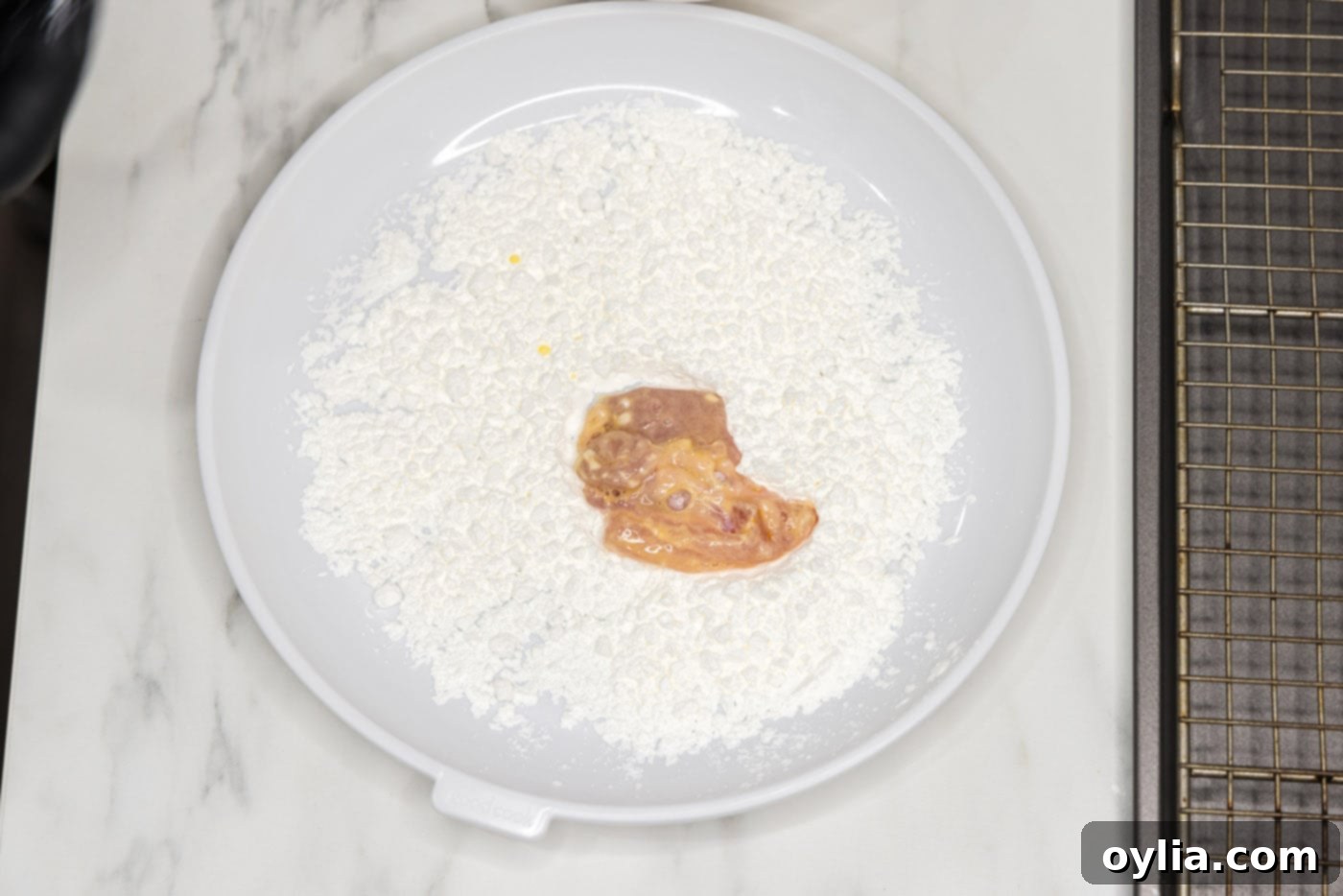 coating chicken piece in cornstarch before frying