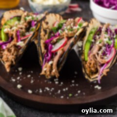 Ultimate Pulled Pork Tacos 7 Delicious Pulled Pork Tacos on a plate, garnished with fresh toppings and ready to eat.