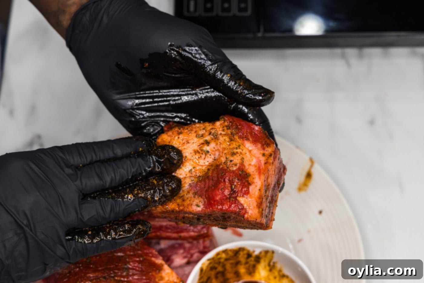 rubbing olive oil and seasoning on short ribs