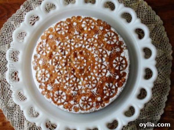 A beautifully baked Merryfield apple cake, presented on a decorative white platter, viewed from above.