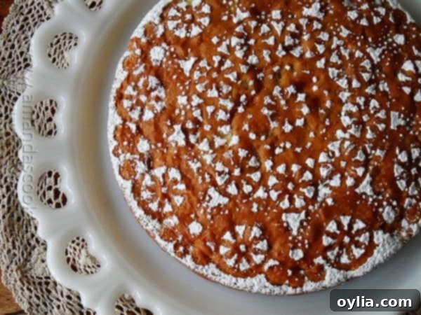 Another enticing overhead photo of a golden-brown Merryfield apple cake resting on a white decorative platter, ready to be served.