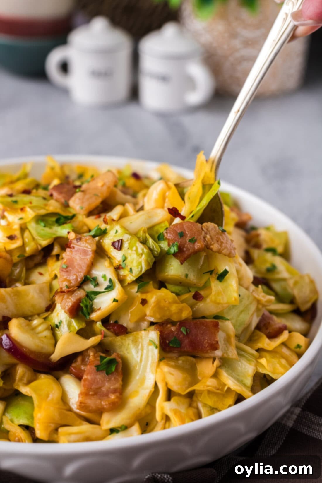 Spoon in a bowl of Spicy Fried Cabbage, highlighting its vibrant color and textures.