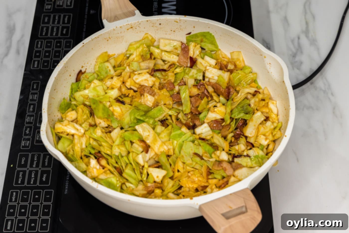 spicy fried cabbage in a skillet with seasonings, perfectly cooked and ready to serve.