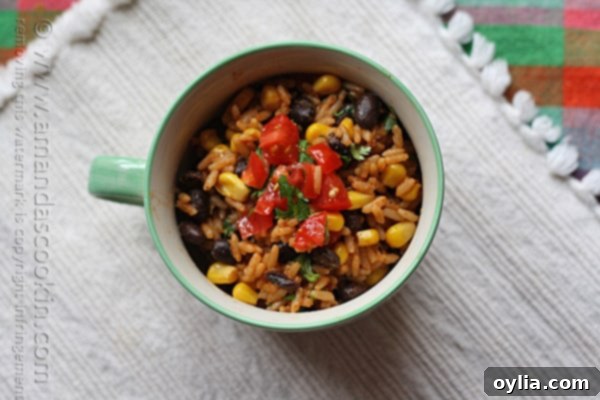 An overhead photo of Spanish rice with black beans and corn in a teal and white bowl, ready to be served.